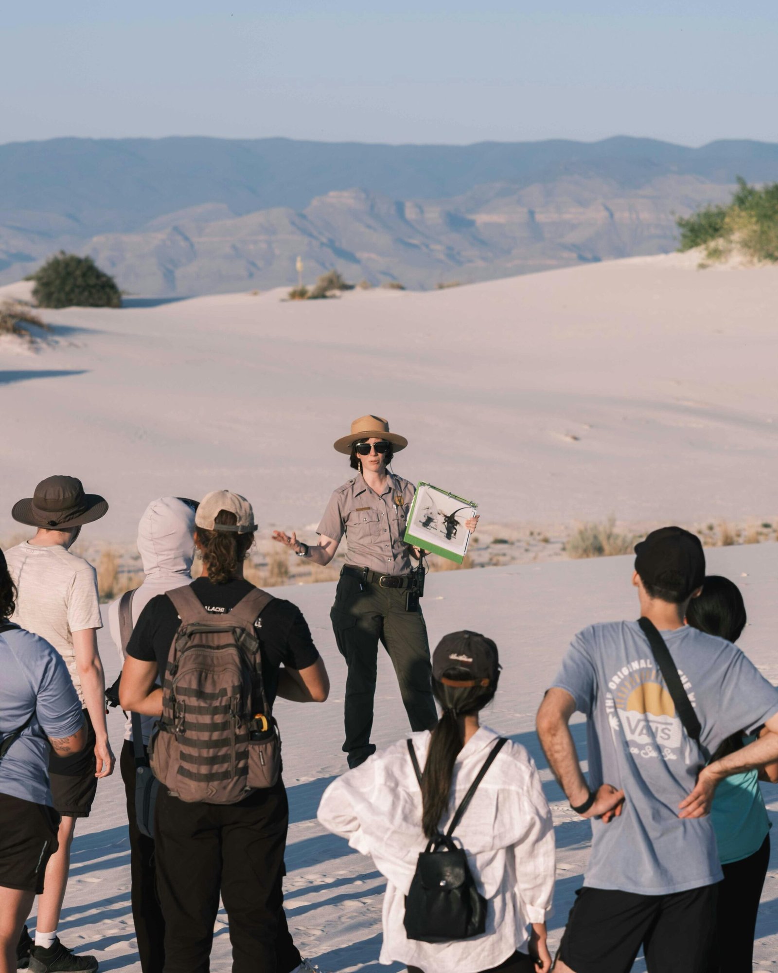 Group of tourists with a guide exploring White Sands National Park during daytime.