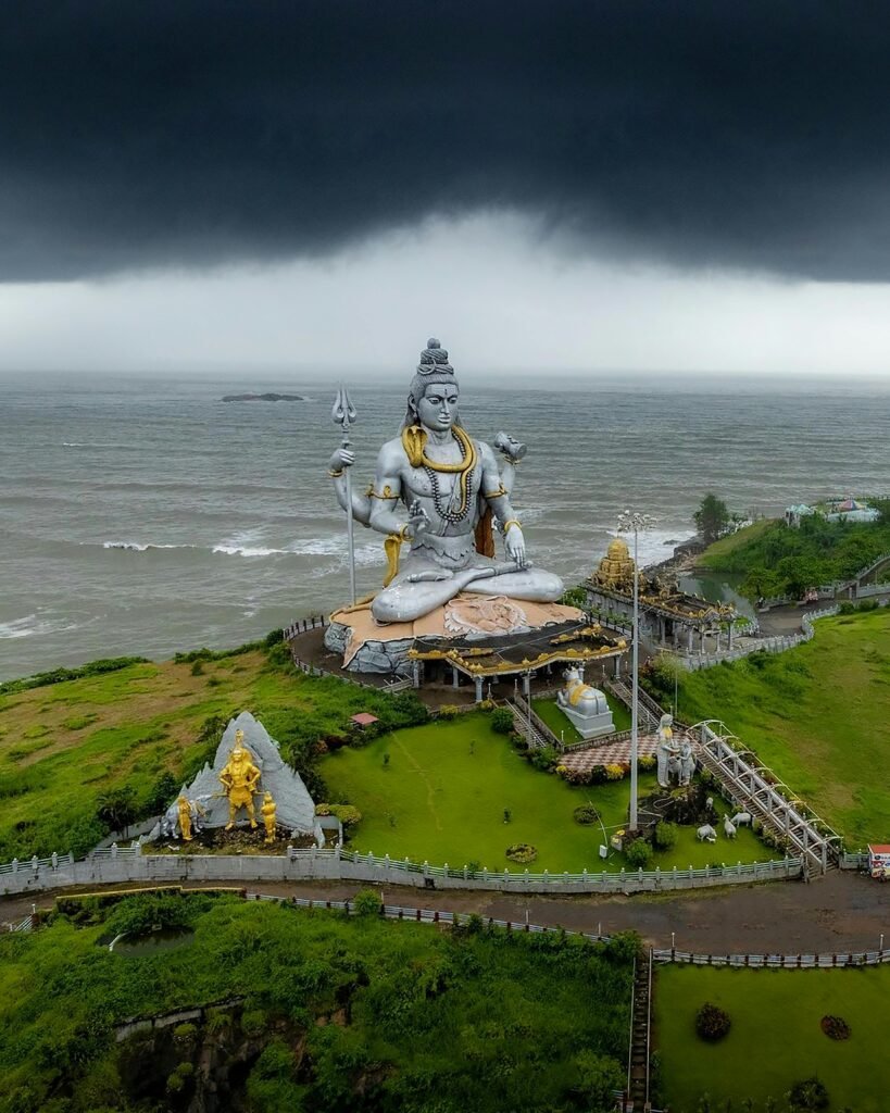 A breathtaking aerial view of the Shiva statue at Murdeshwar with stormy skies over the Arabian Sea.