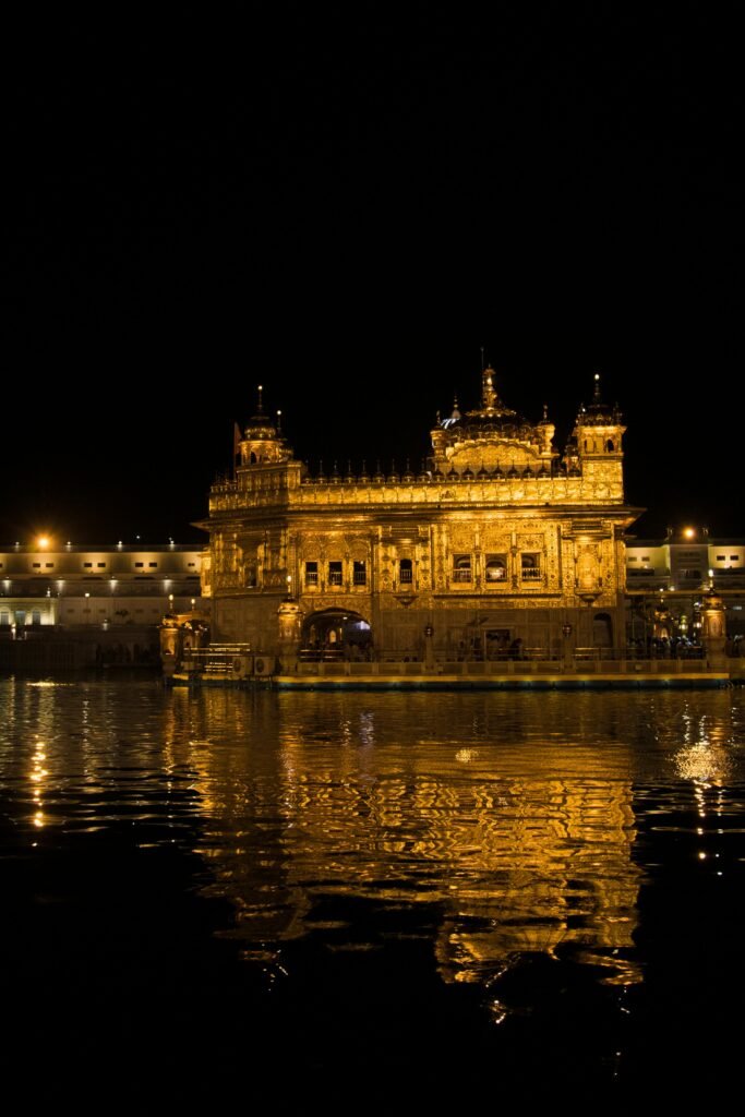 Illuminated Golden Temple reflecting in water at night in Amritsar, Punjab, India.