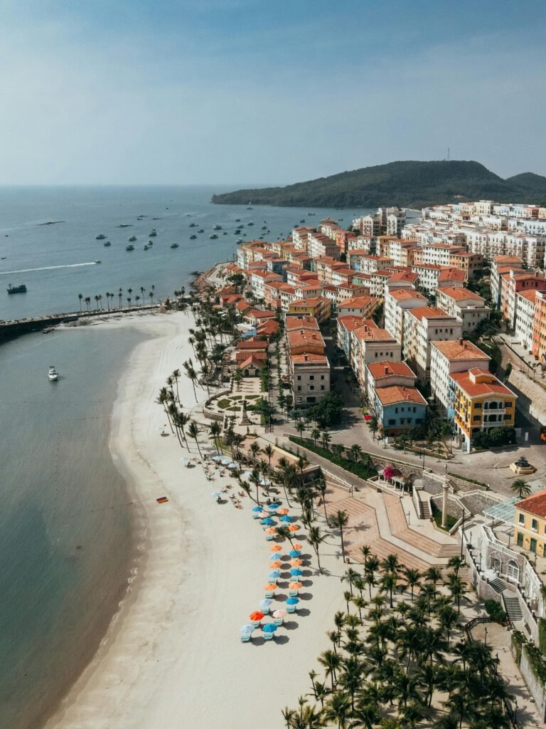 Stunning beachfront aerial view of Phu Quoc, showcasing colorful umbrellas and vibrant architecture.